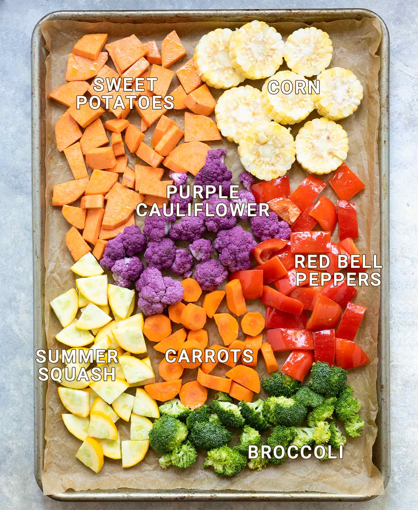 Chopped vegetables spread out on a baking sheet, ready for roasting
