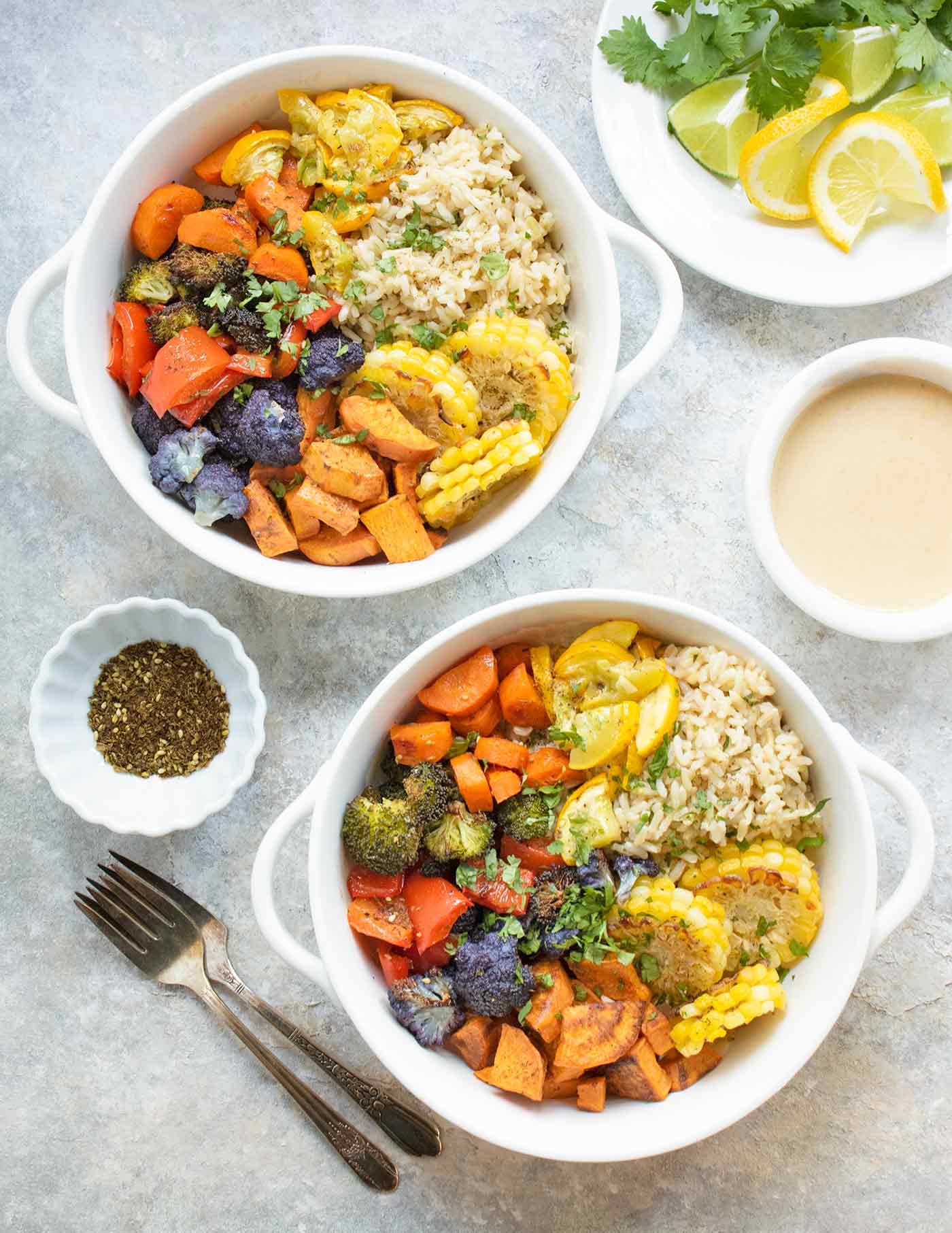 Two bowls of Mediterranean roasted vegetables served with brown rice.