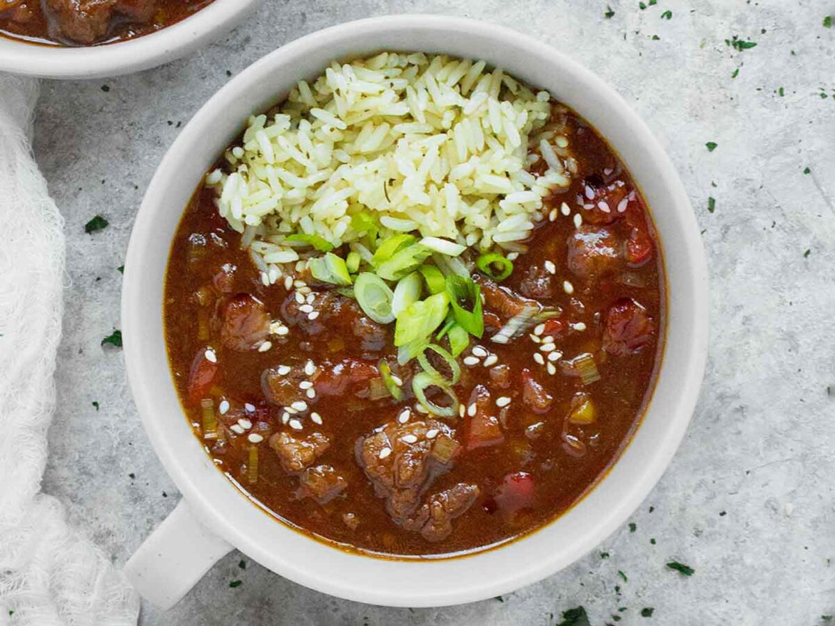 Overhead view of Mongolian Beef Soup with rice in a light gray bowl.