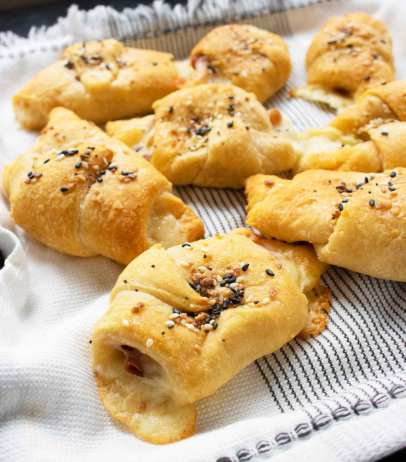Side-angled close-up of Mortadella Stuffed Crescent Rolls on a tray.