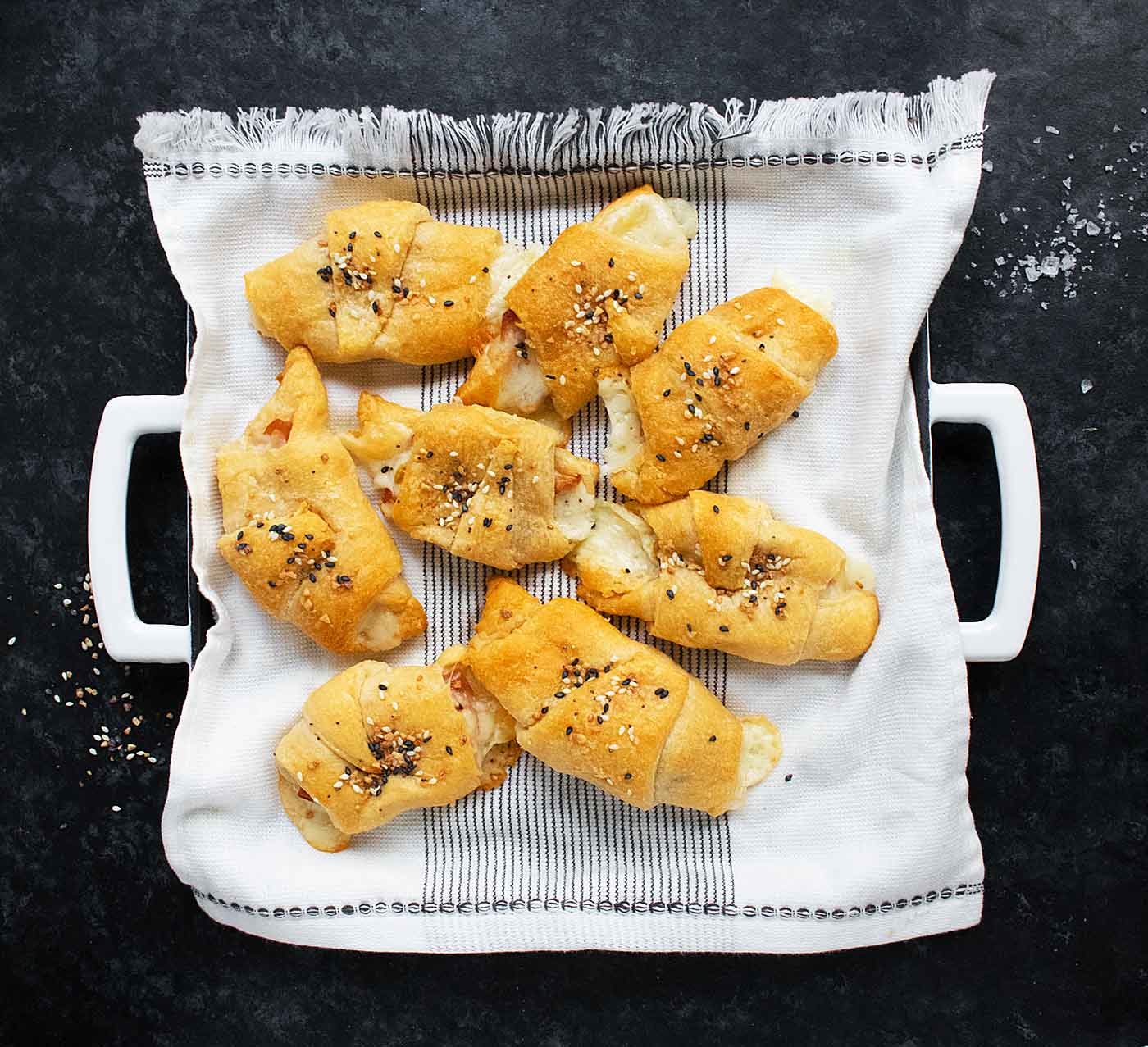 Overhead view of Mortadella Stuffed Crescent Rolls on a towel-lined serving tray.