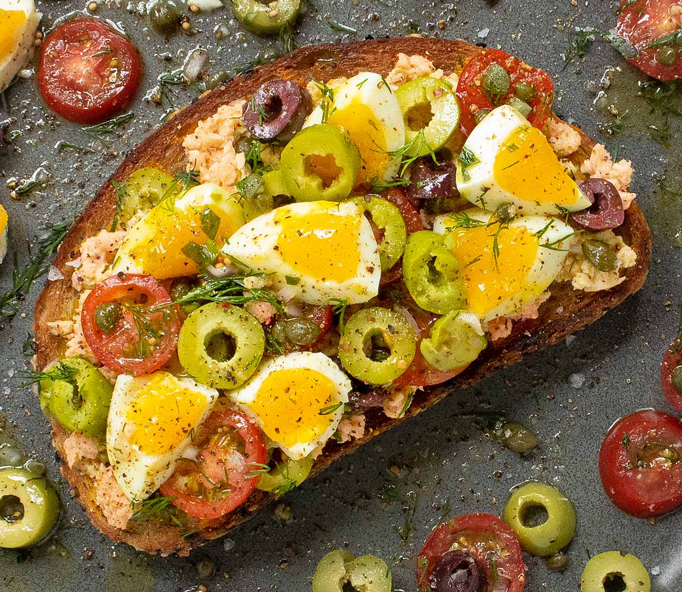 Overhead view of Nicoise Fried Toast with Jammy Eggs on a gray plate.