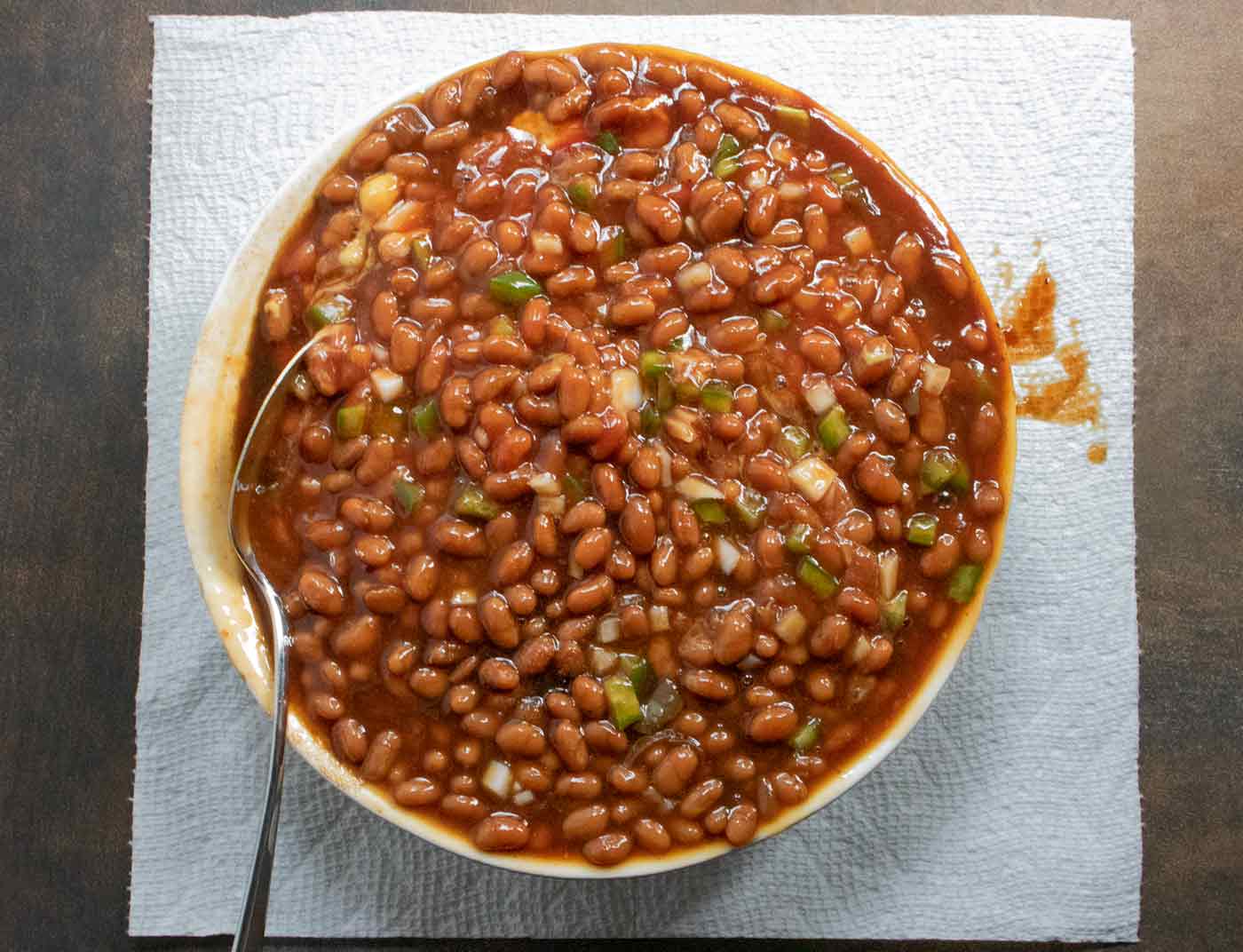 Mixing the beans and all other ingredients together in a bowl.