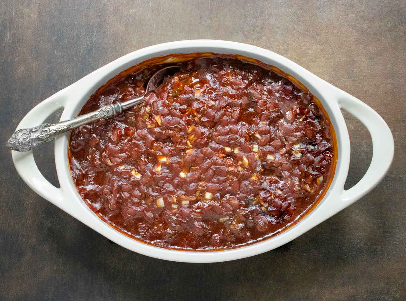 Oven-baked Canned Baked Beans in an oval white baking dish.