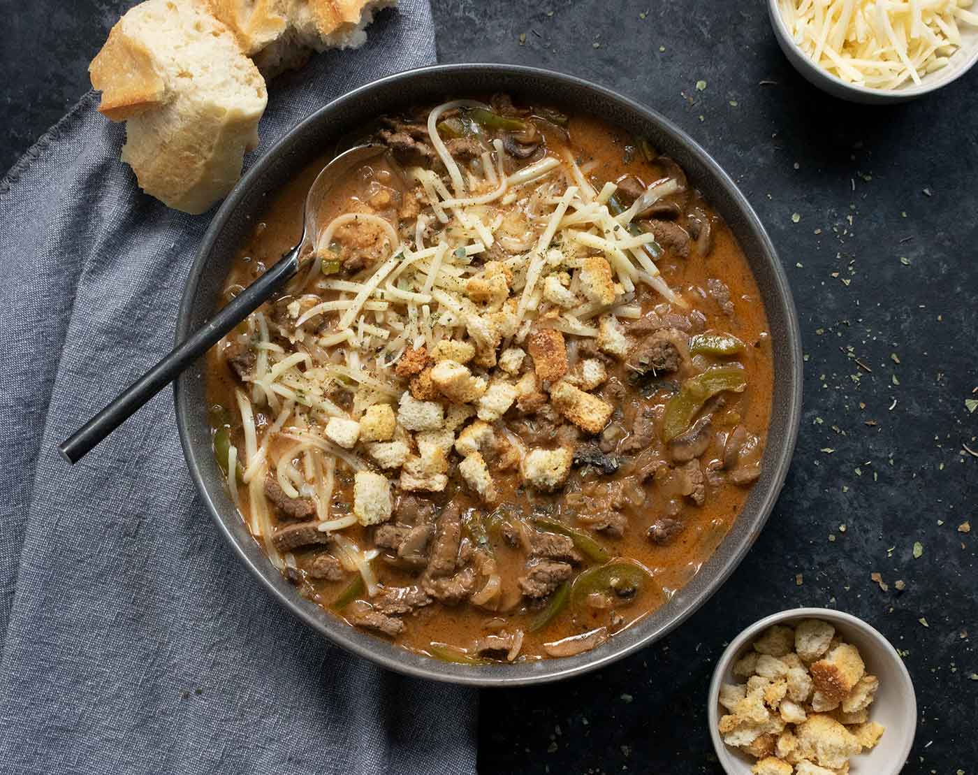 Philly Cheesesteak Soup in a gray bowl with a spoon