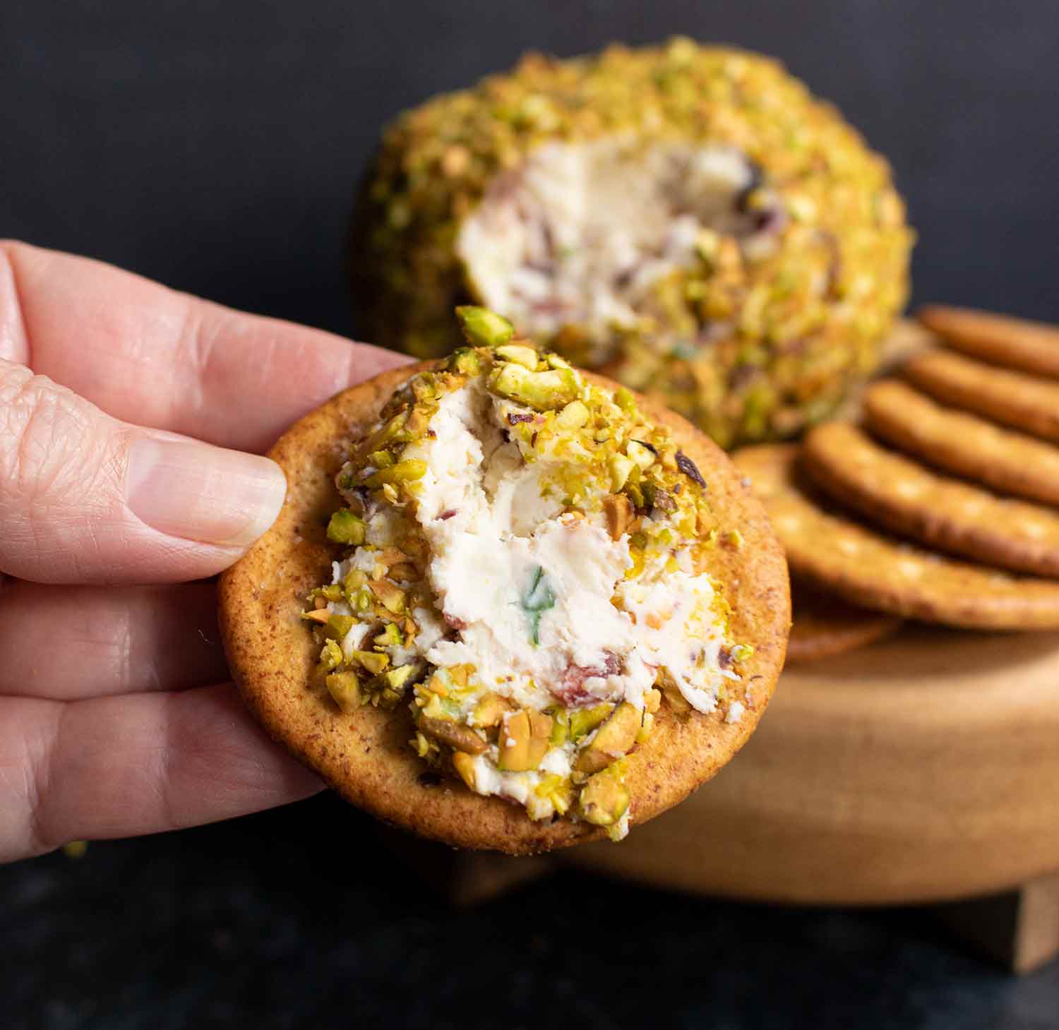 Pistachio Cranberry Cheese Ball spread on a cracker.
