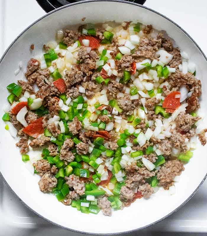 Onions, green bell peppers, and pepperoni sauteing in the sausage.