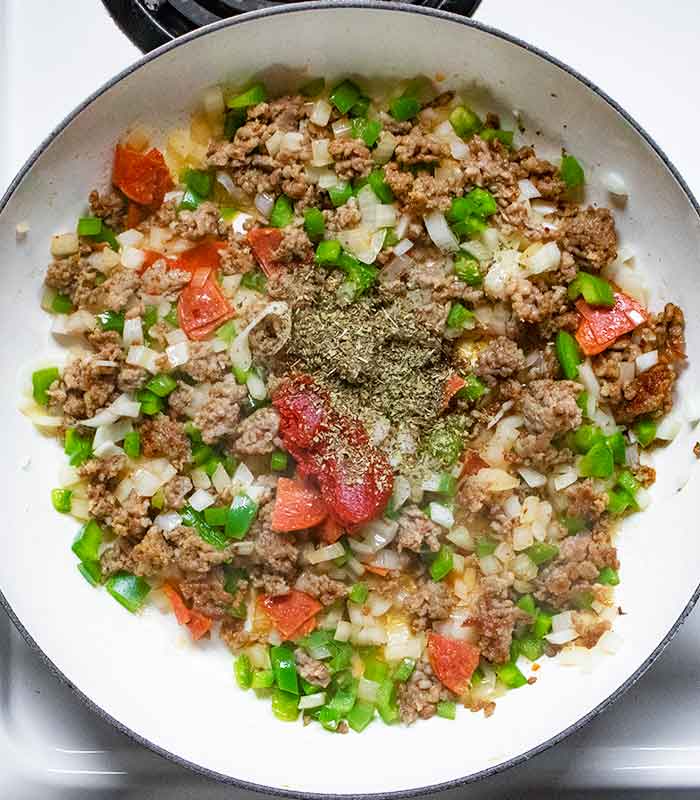 Adding the seasonings and tomato paste to the mixture.