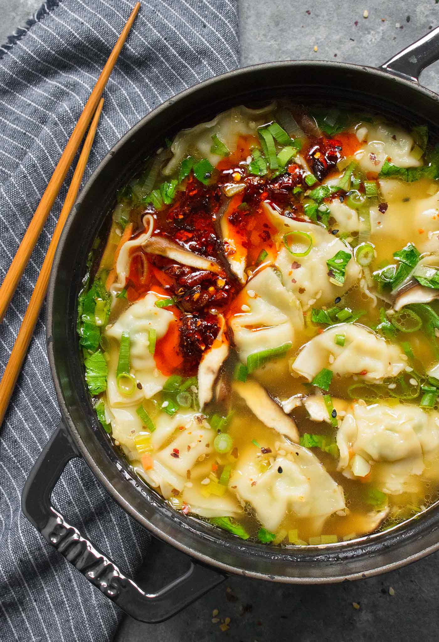 Overhead close-up of a Dutch oven filled with Potsticker Soup, with chopsticks on the side.