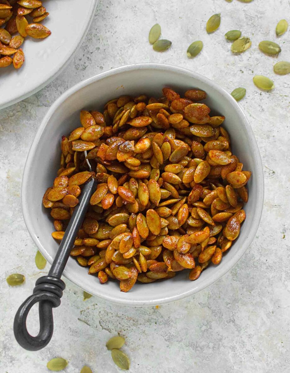 Honey Sriracha Roasted Pumpkin Seeds in a white ramekin.