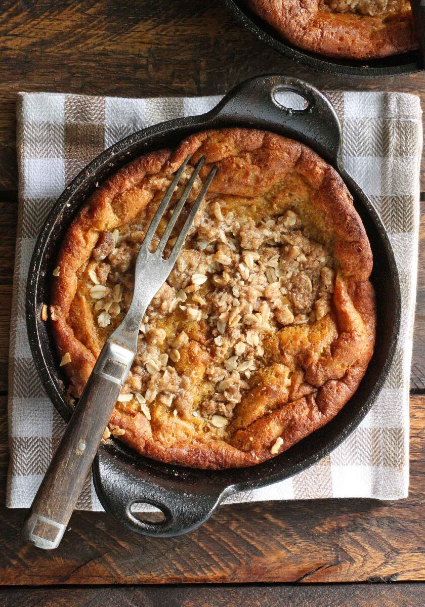 A Pumpkin Pie Dutch Baby in a cast iron server with a fork.