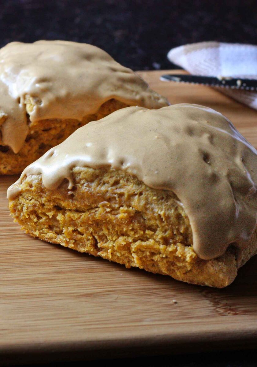 A glazed Pumpkin Spice Scone in a cutting board, ready to eat.