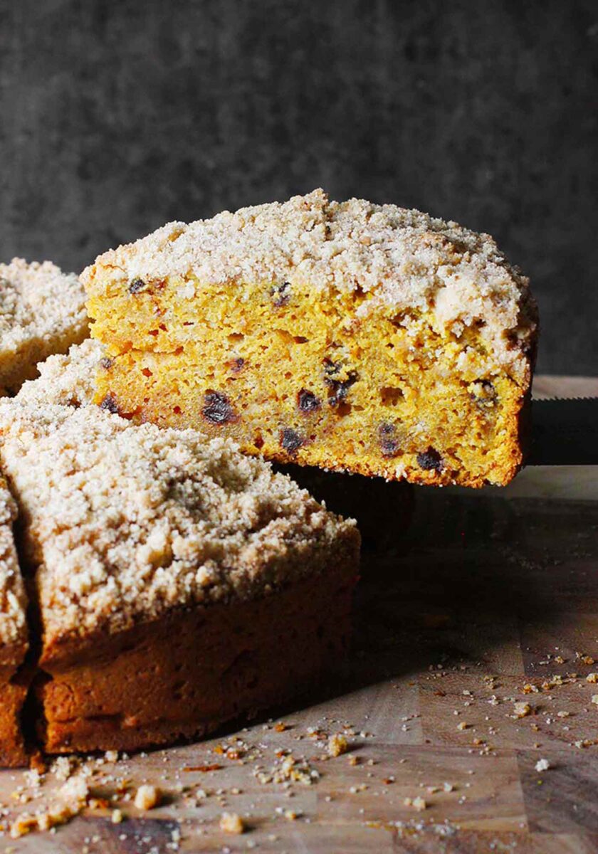 A slice of Pumpkin Spice Crumb Cake perched on a serving knife.