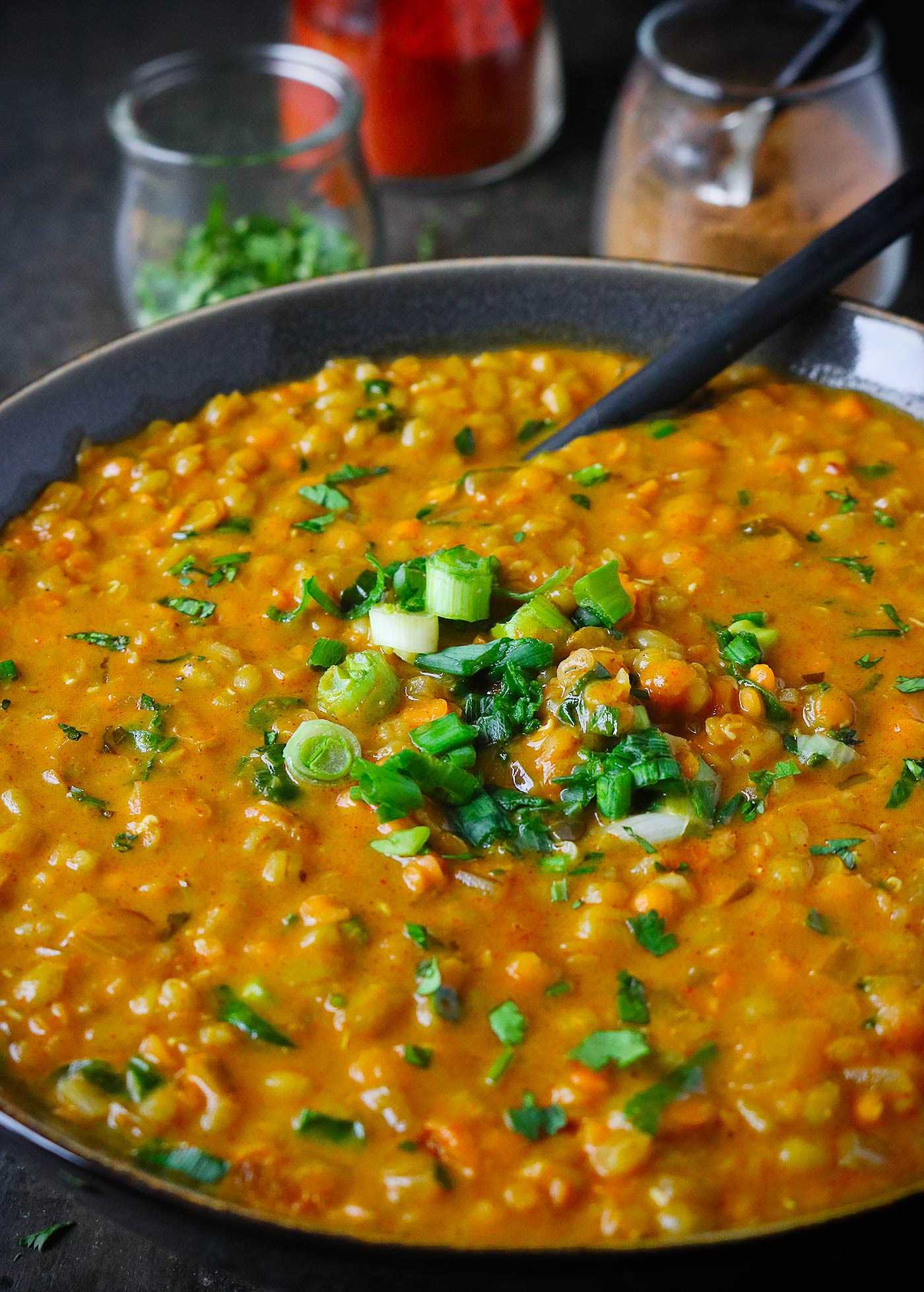 Red Lentil Masala Soup in a bowl with a spoon
