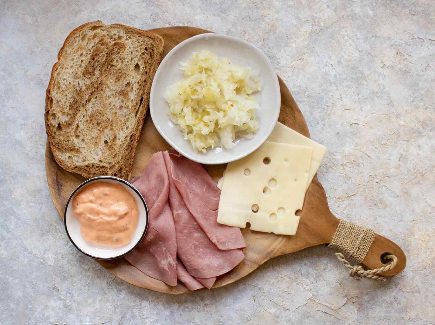 Ingredients for Reuben Fried Toast on a wooden cutting board.