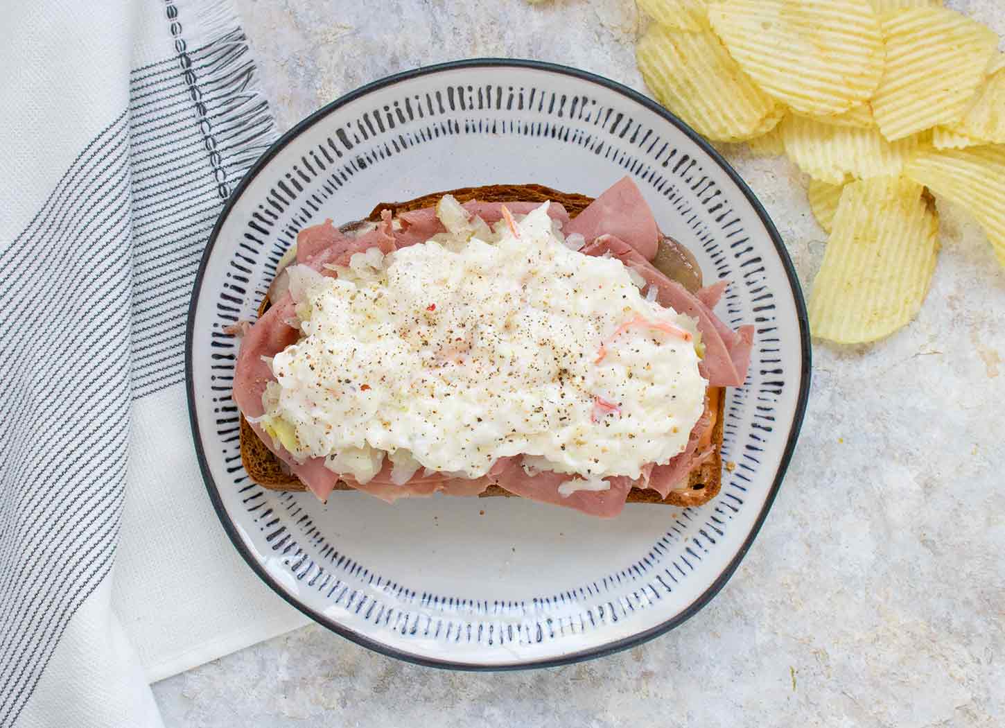 Open-faced Reuben Fried Toast on a plate with black trim.