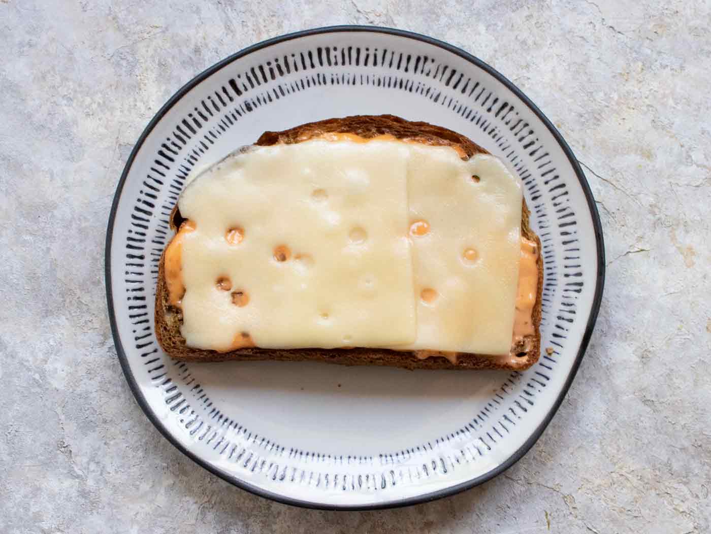 Melted Swiss cheese on fried toast.