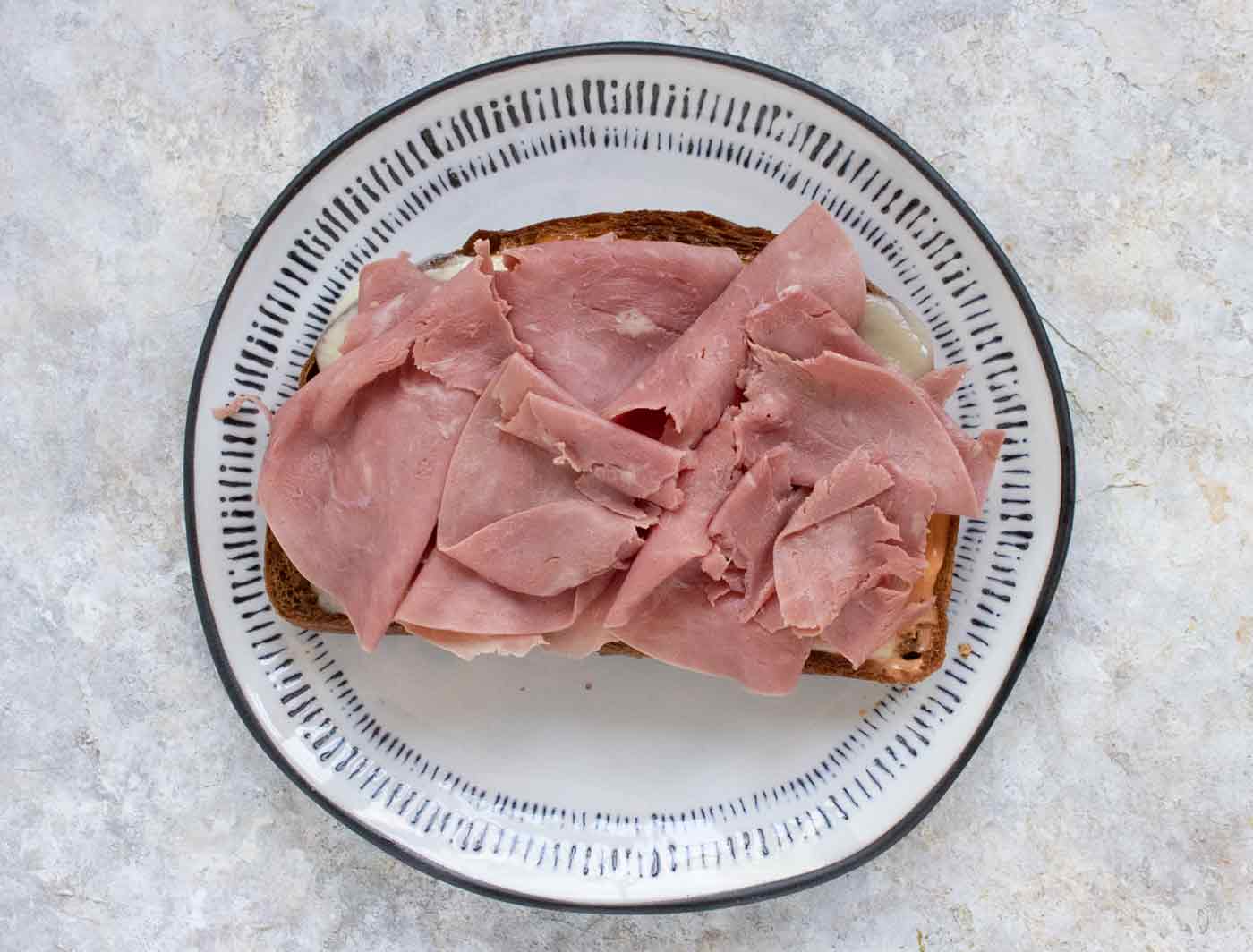 Thin slices of corned beef on a slice of fried toast.