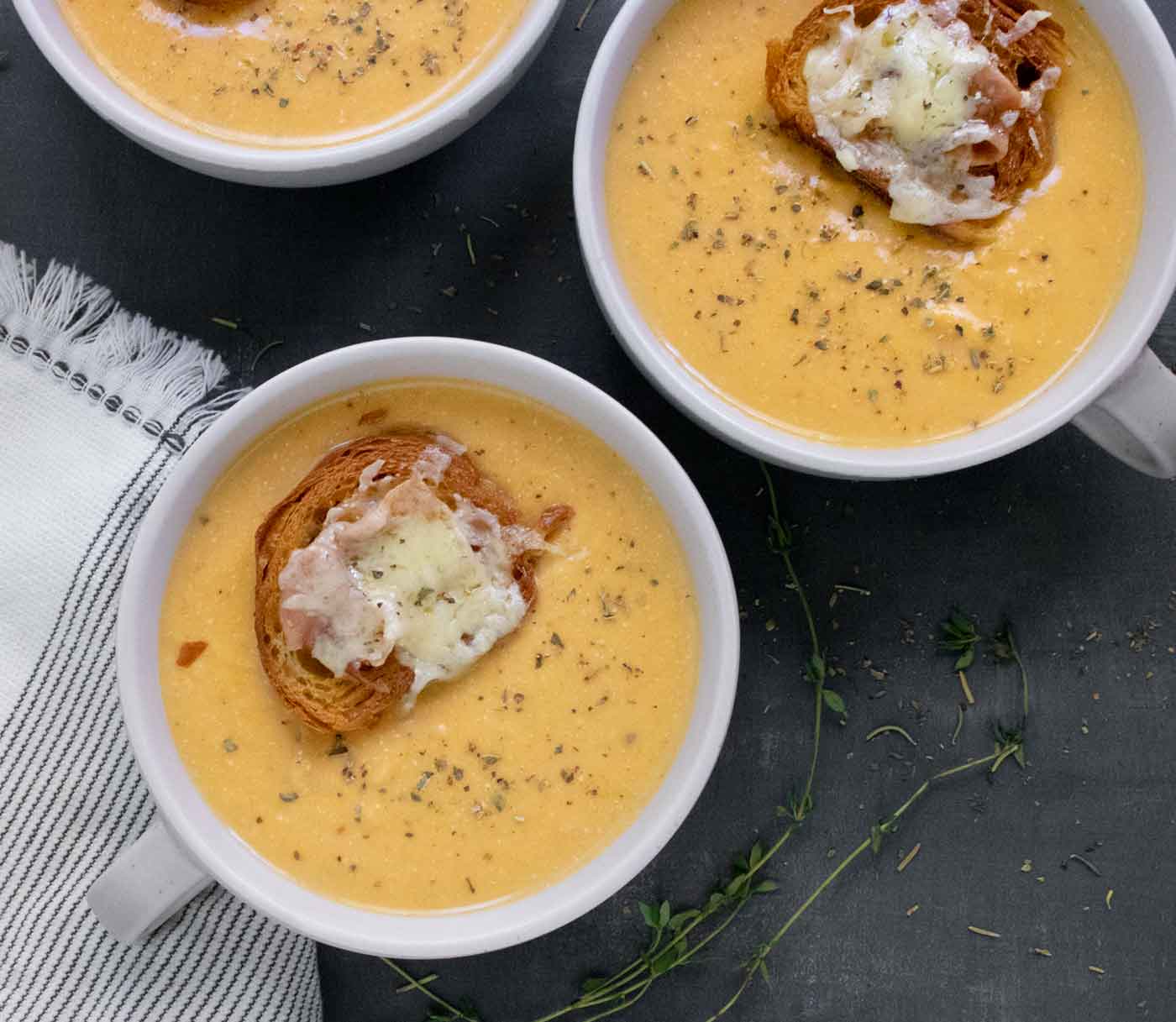 Overhead photo of three bowls of Roasted Winter Squash and Feta Soup.