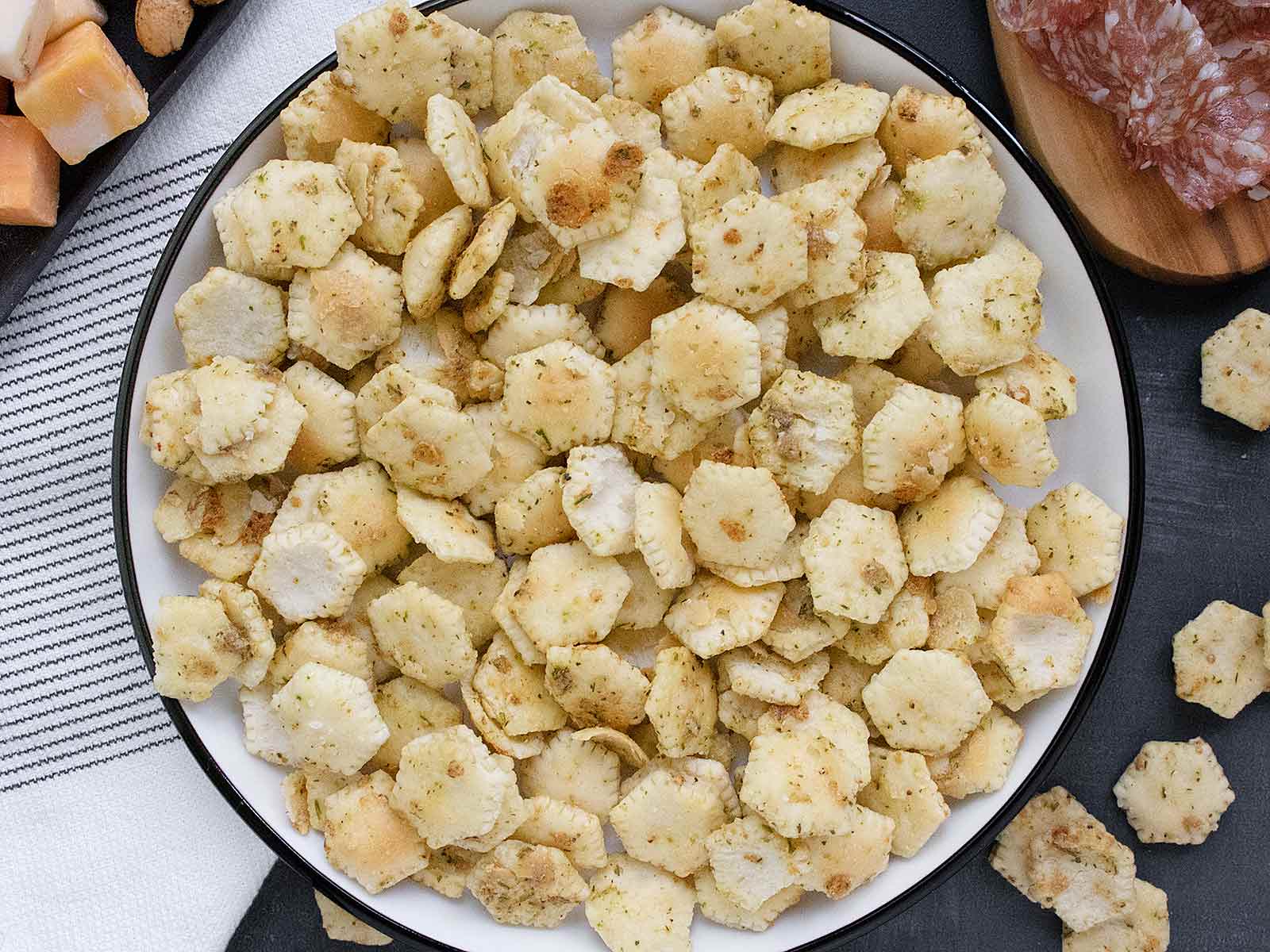 Overhead view of Seasoned Oyster Crackers on a white plate with a black rim.