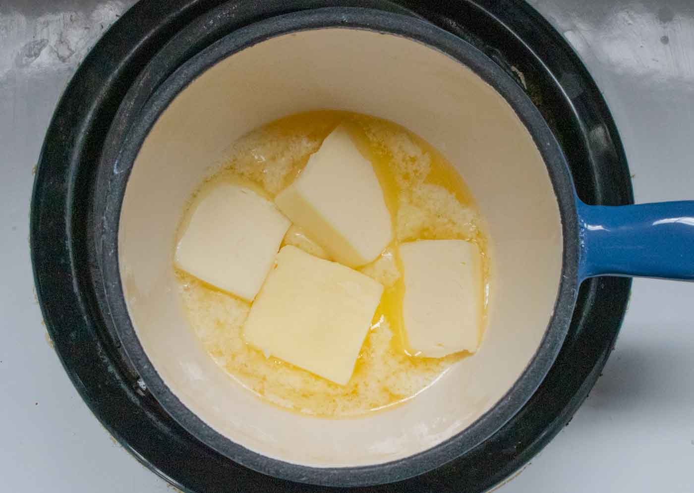 Butter melting in a pot on the stove.