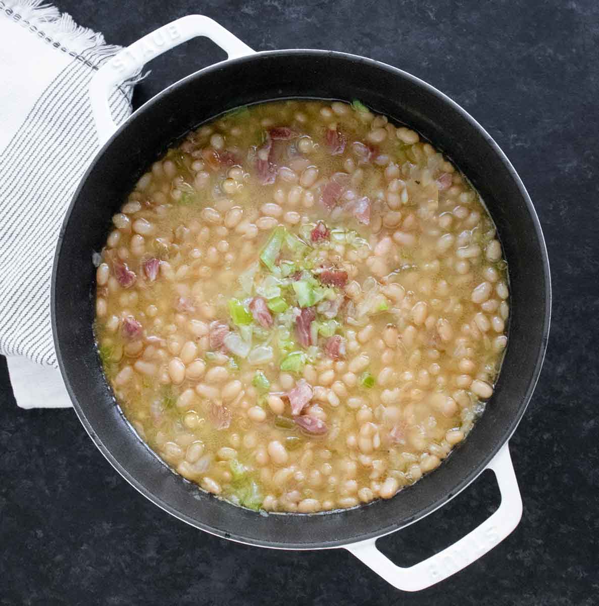 Overhead view of Senate Bean Soup in a large white Dutch oven.