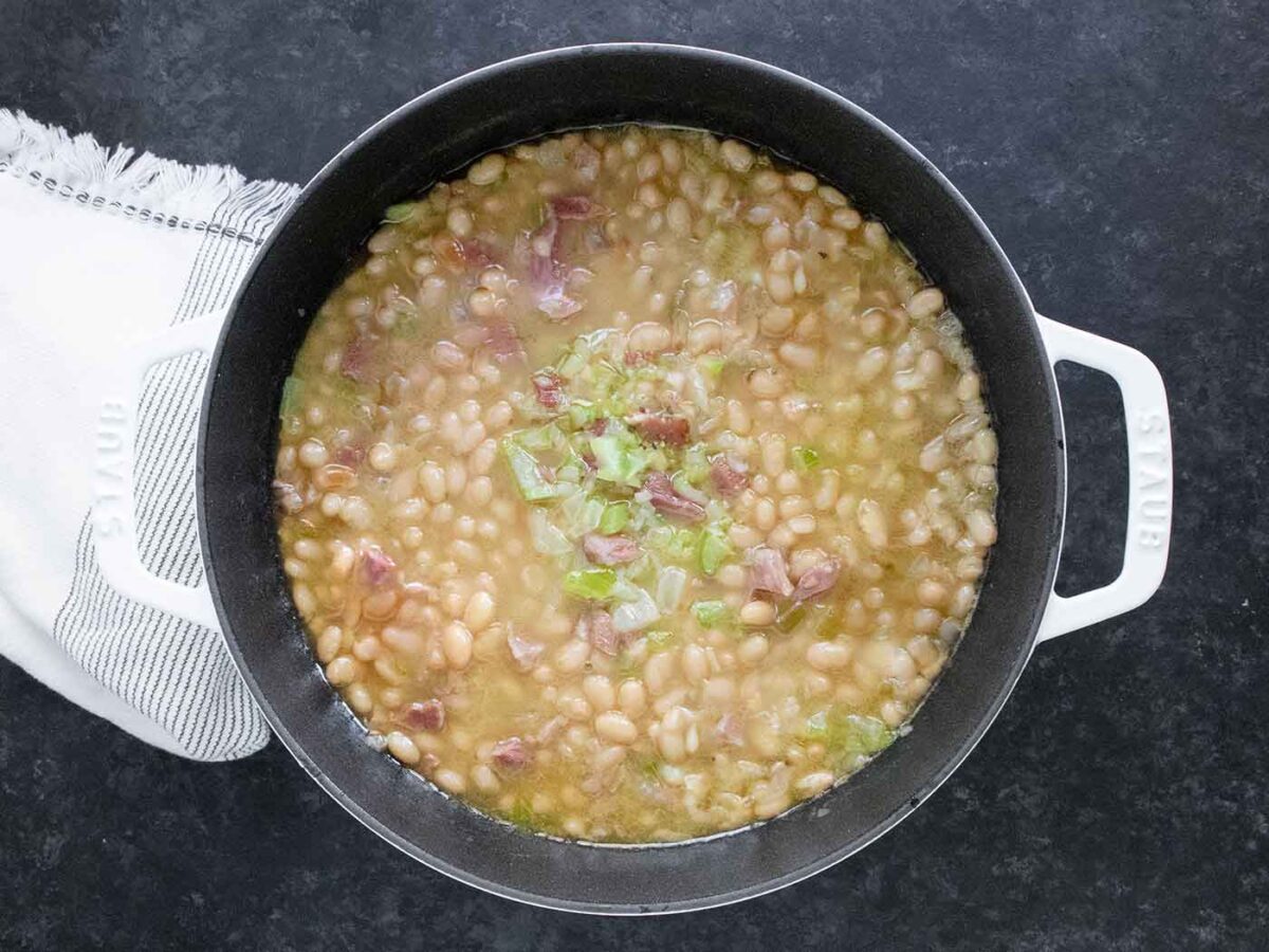 Overhead view of Senate Bean Soup in a large white dutch oven.