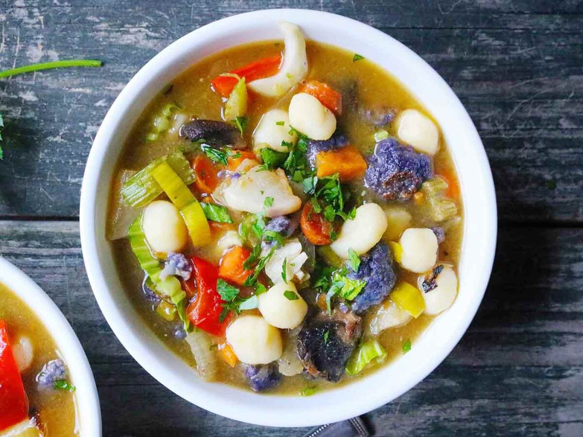 Overhead view of Sheet Pan Roasted Vegetable Soup with Gnocchi in a white bowl.