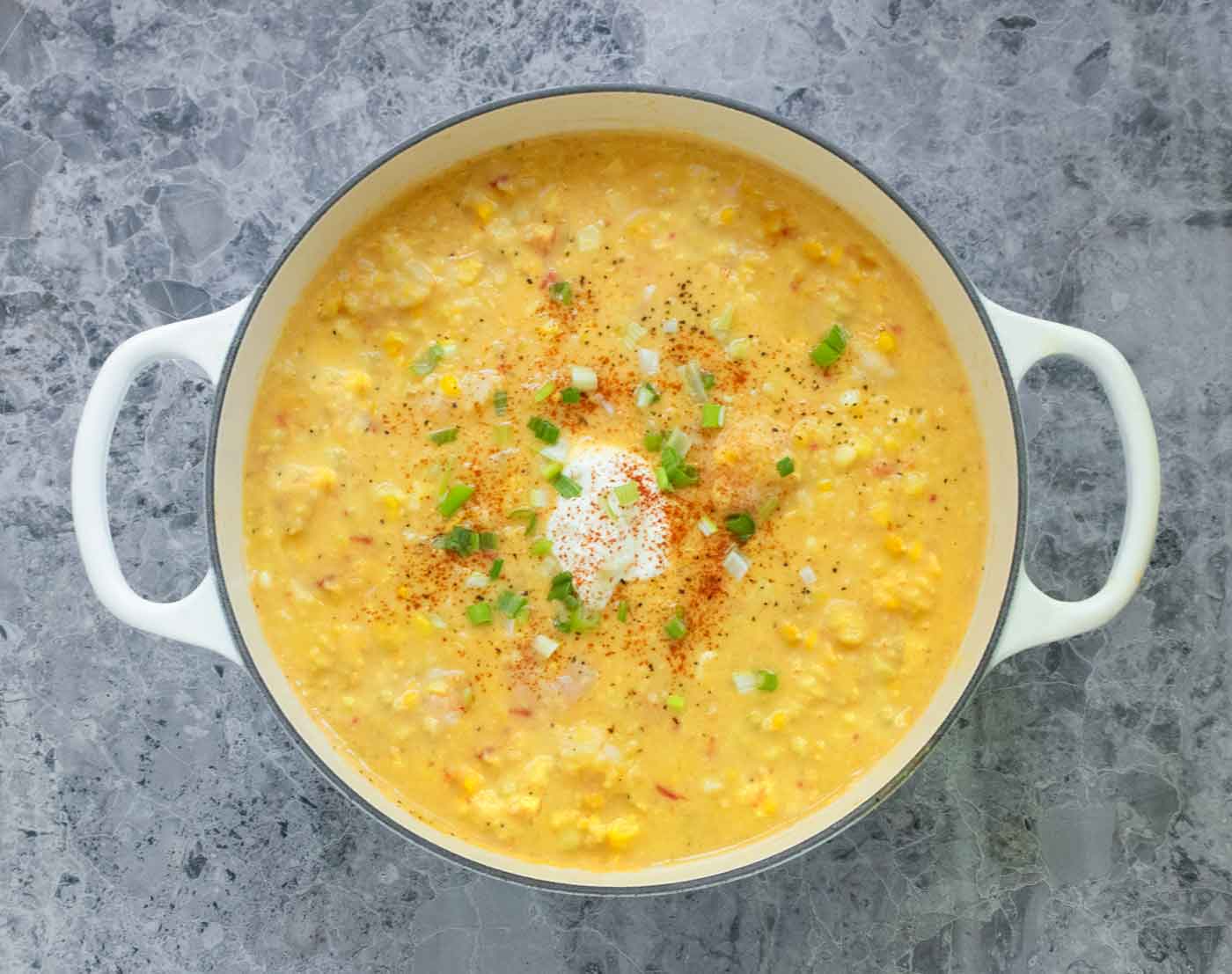 Overhead view of Shrimp and Corn Chowder in a large white Dutch oven.