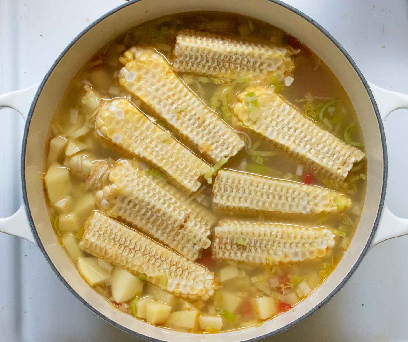 Potatoes, corn cobs and broth added to the pot.