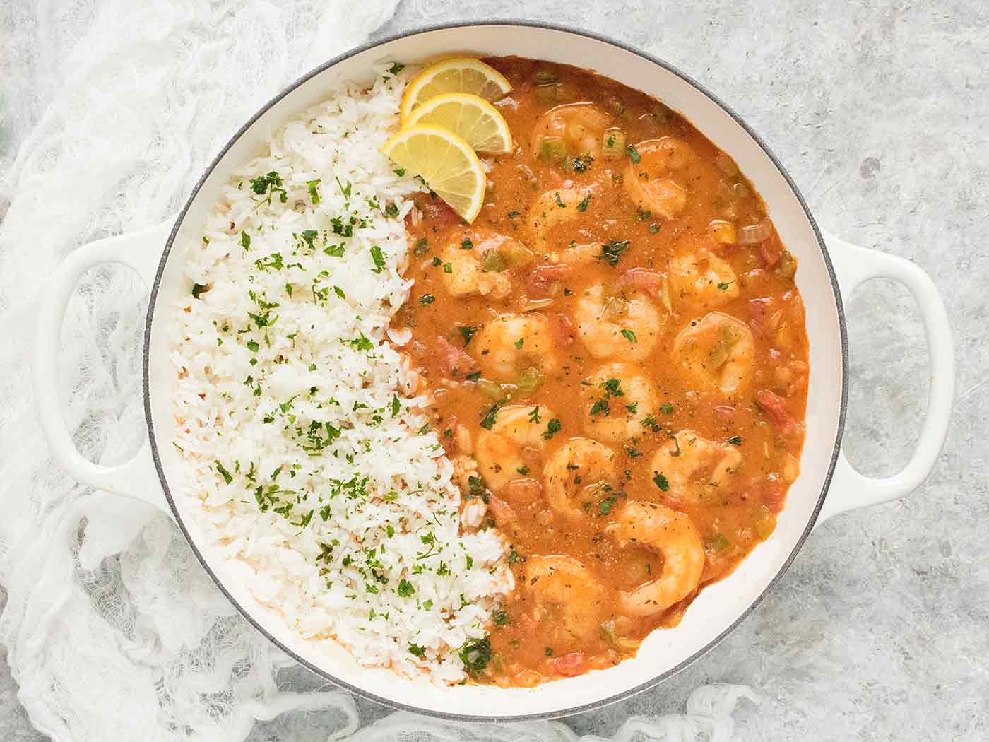 Shrimp Etouffee with rice in a large white Dutch oven.