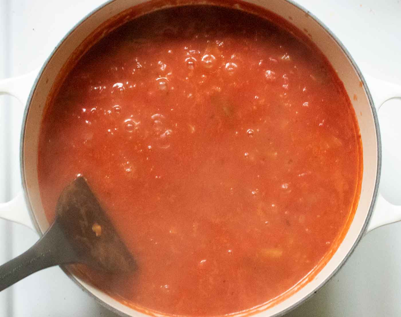 Broth and tomatoes coming up to a bubbly boil.