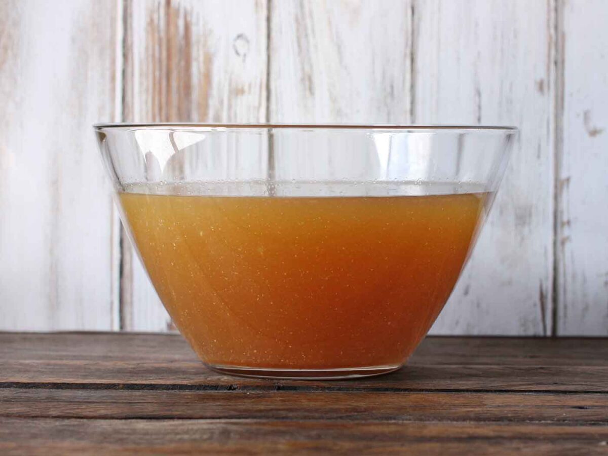 Side view of a large glass bowl of Slow Cooker Turkey Stock.