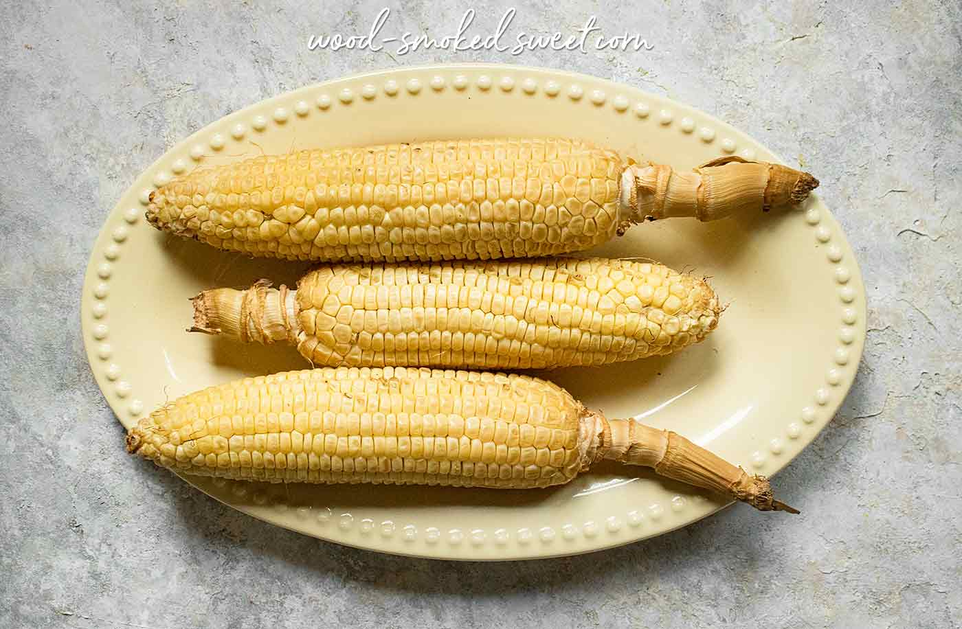 Three ears of smoked corn on a platter