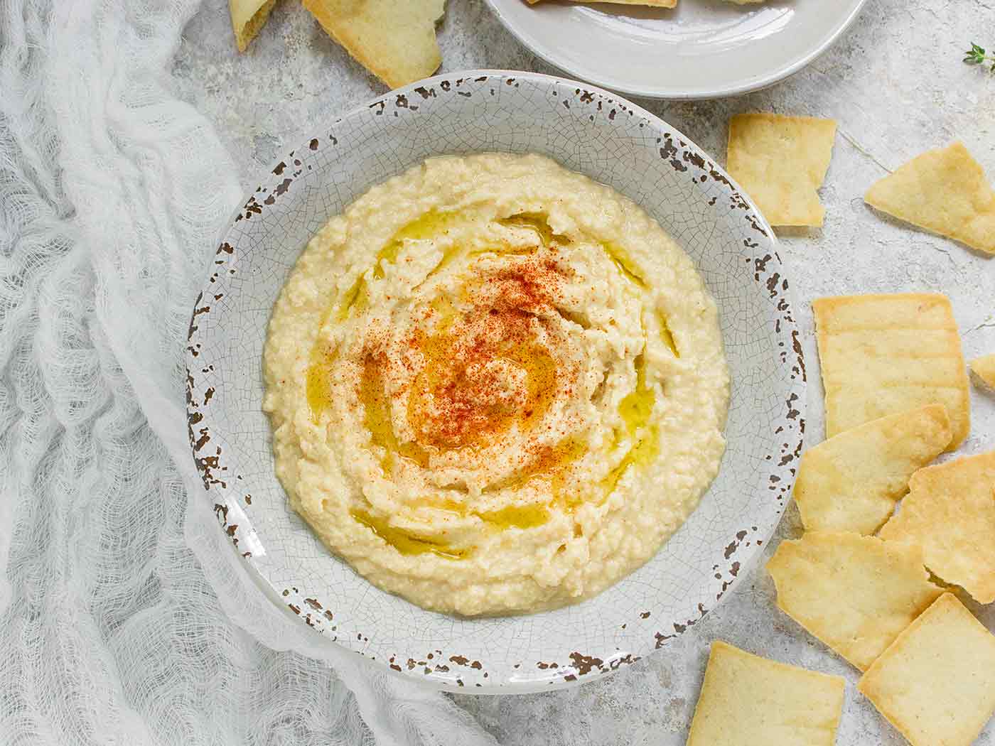 Smoked corn hummus in a bowl with a side of pita chips