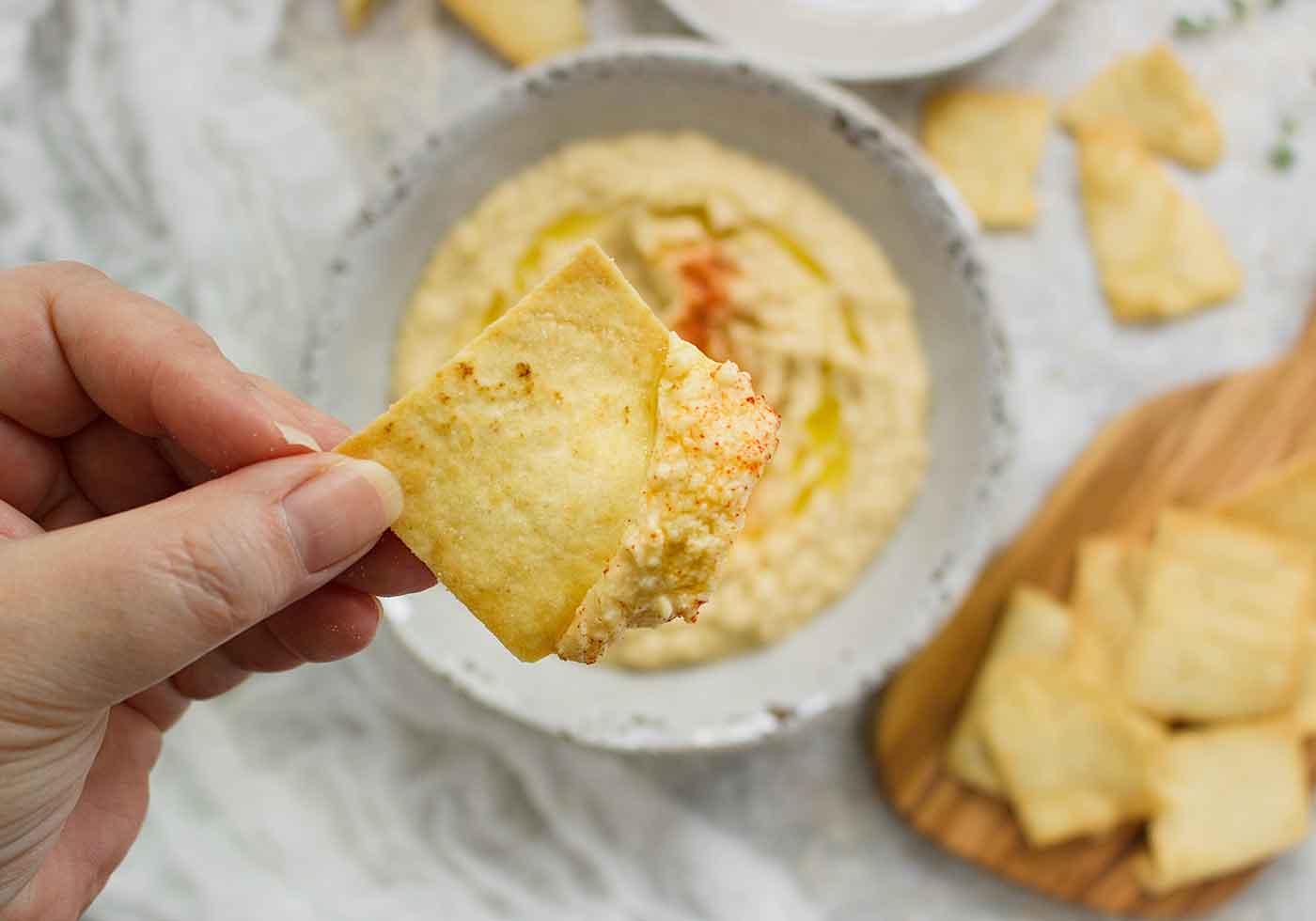 Close-up of a pita chip loaded up with Smoked Corn Hummus