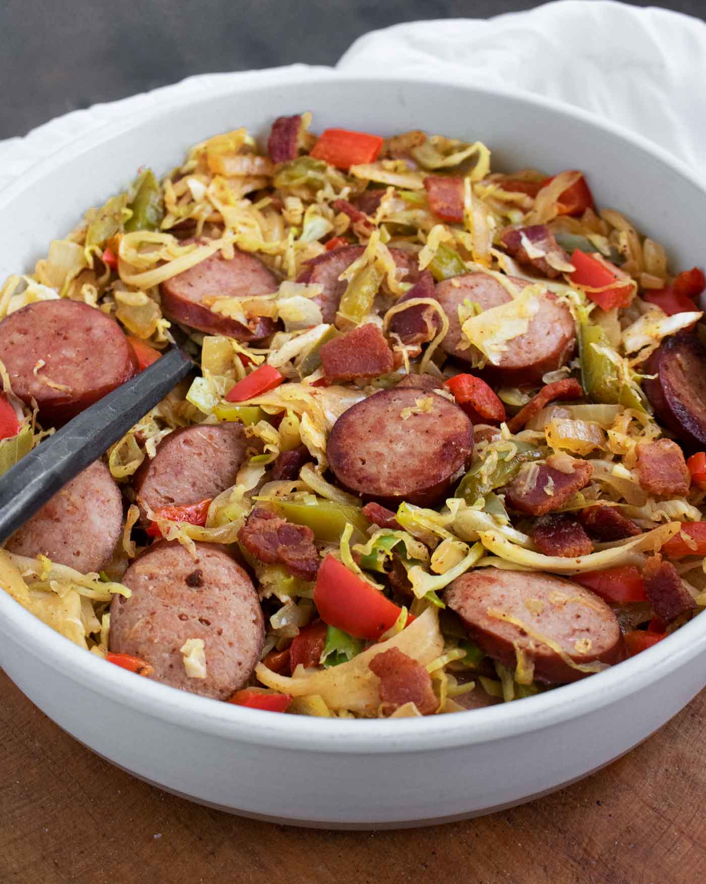 Side angled view of a bowl of Southern Fried Cabbage with a fork.