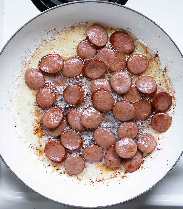 Smoked sausage slices cooking in the pot.