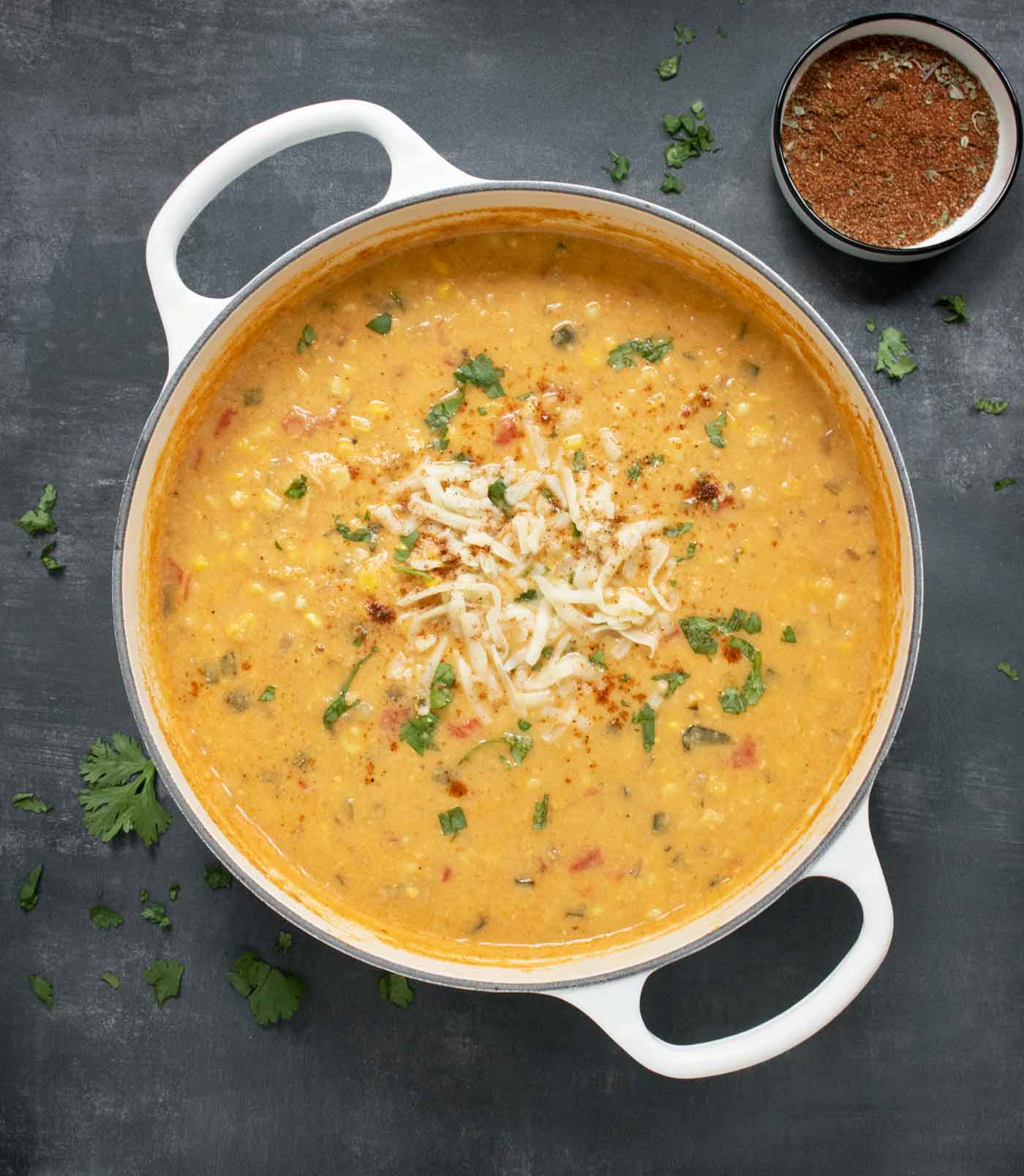 An overhead view of a pot of Southwest Corn Chowder on a black background.