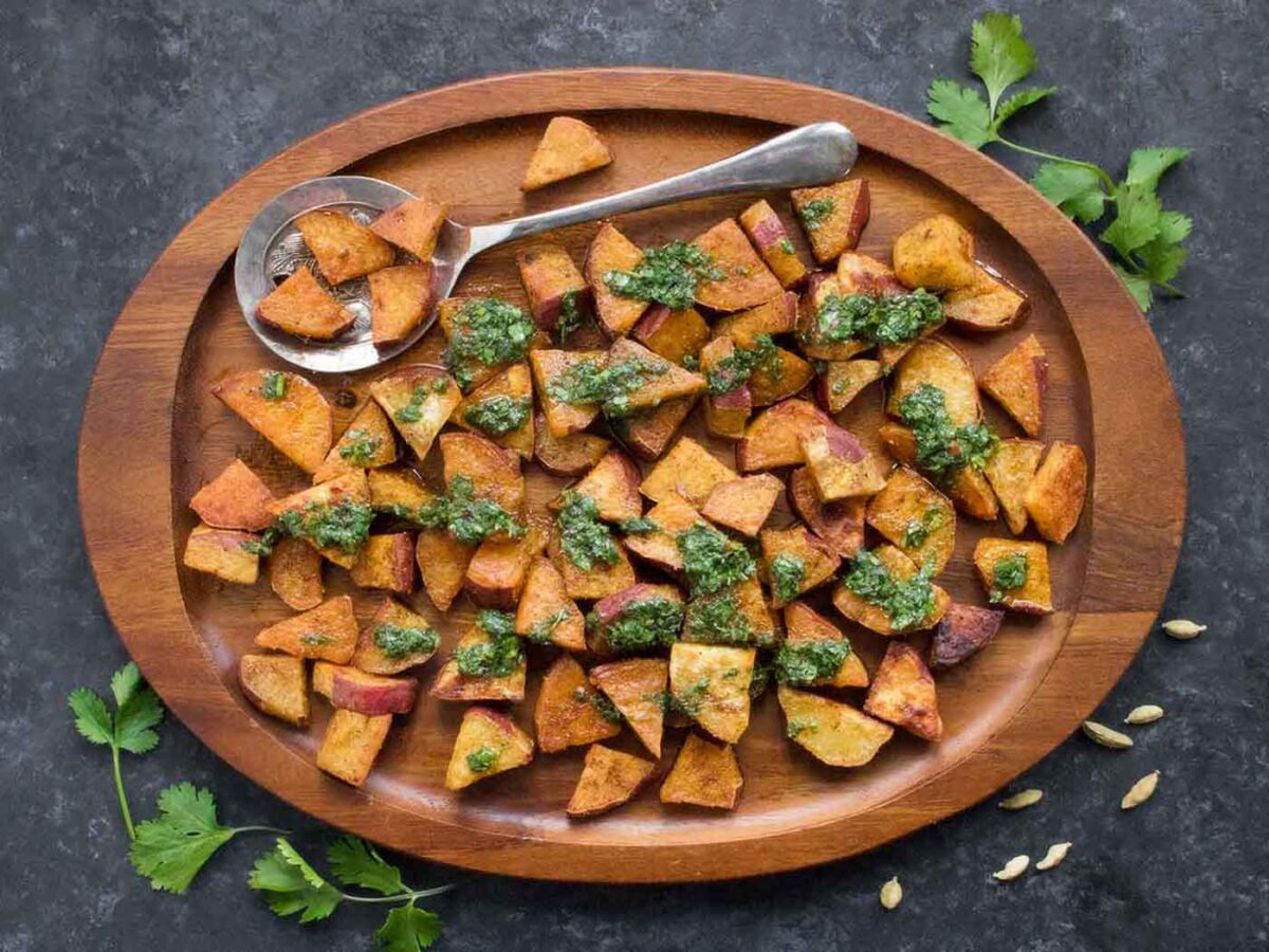 Overhead view of Spiced Sweet Potatoes on a wooden serving board.