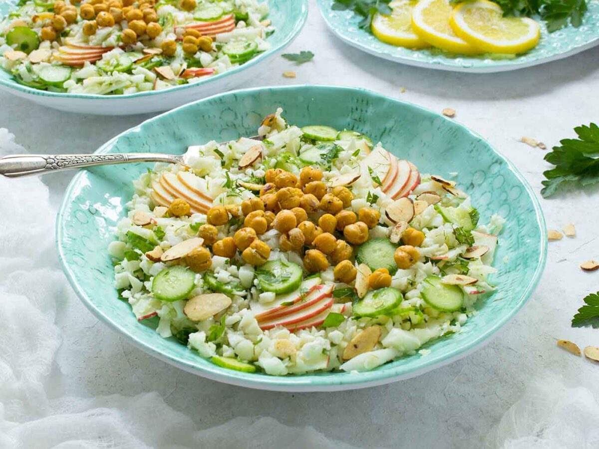 Side angled view of Summer Cauliflower Power Salad in a light blue bowl.