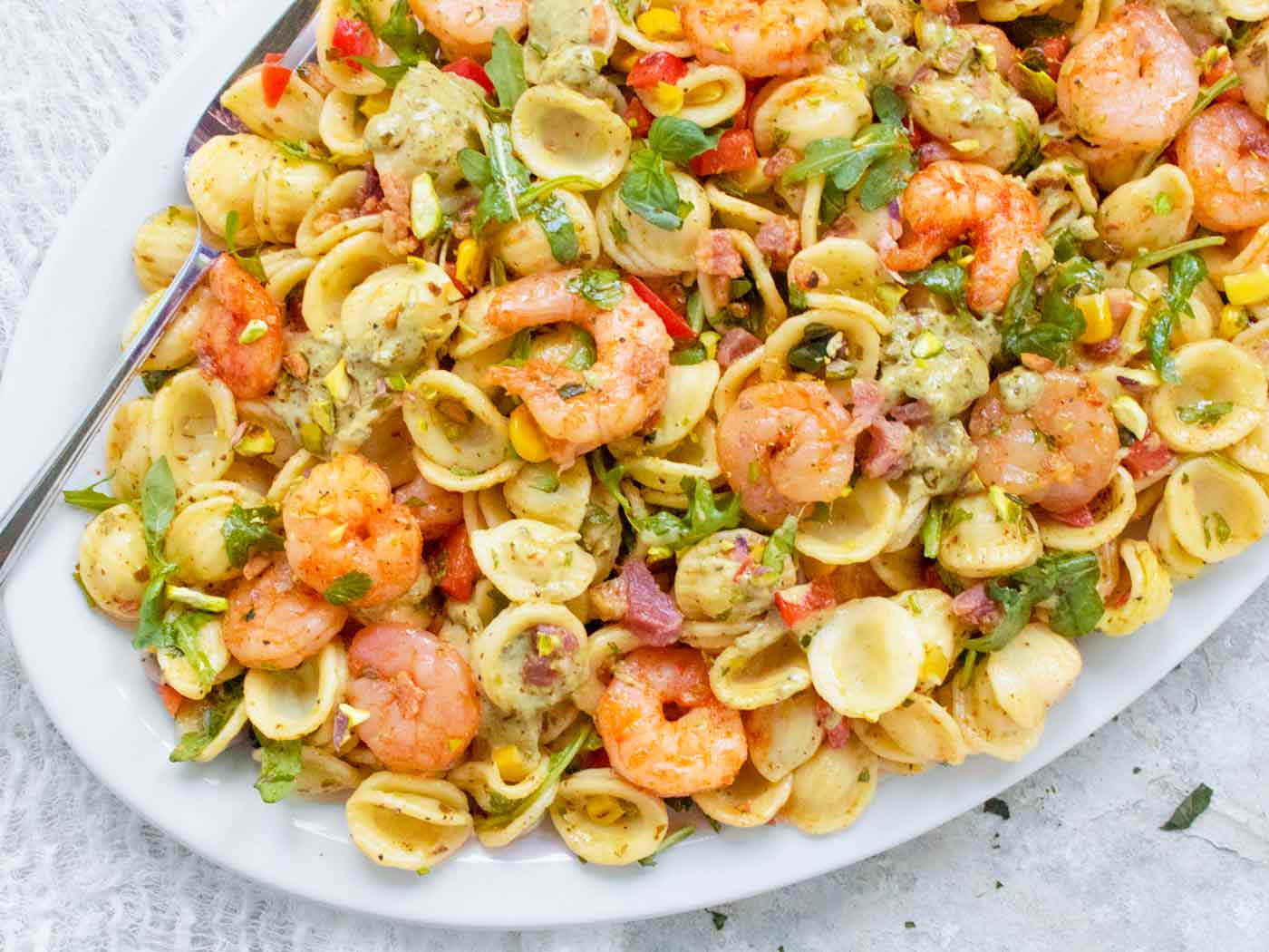 Overhead view of a platter with Summer Shrimp & Pancetta Pasta Salad.