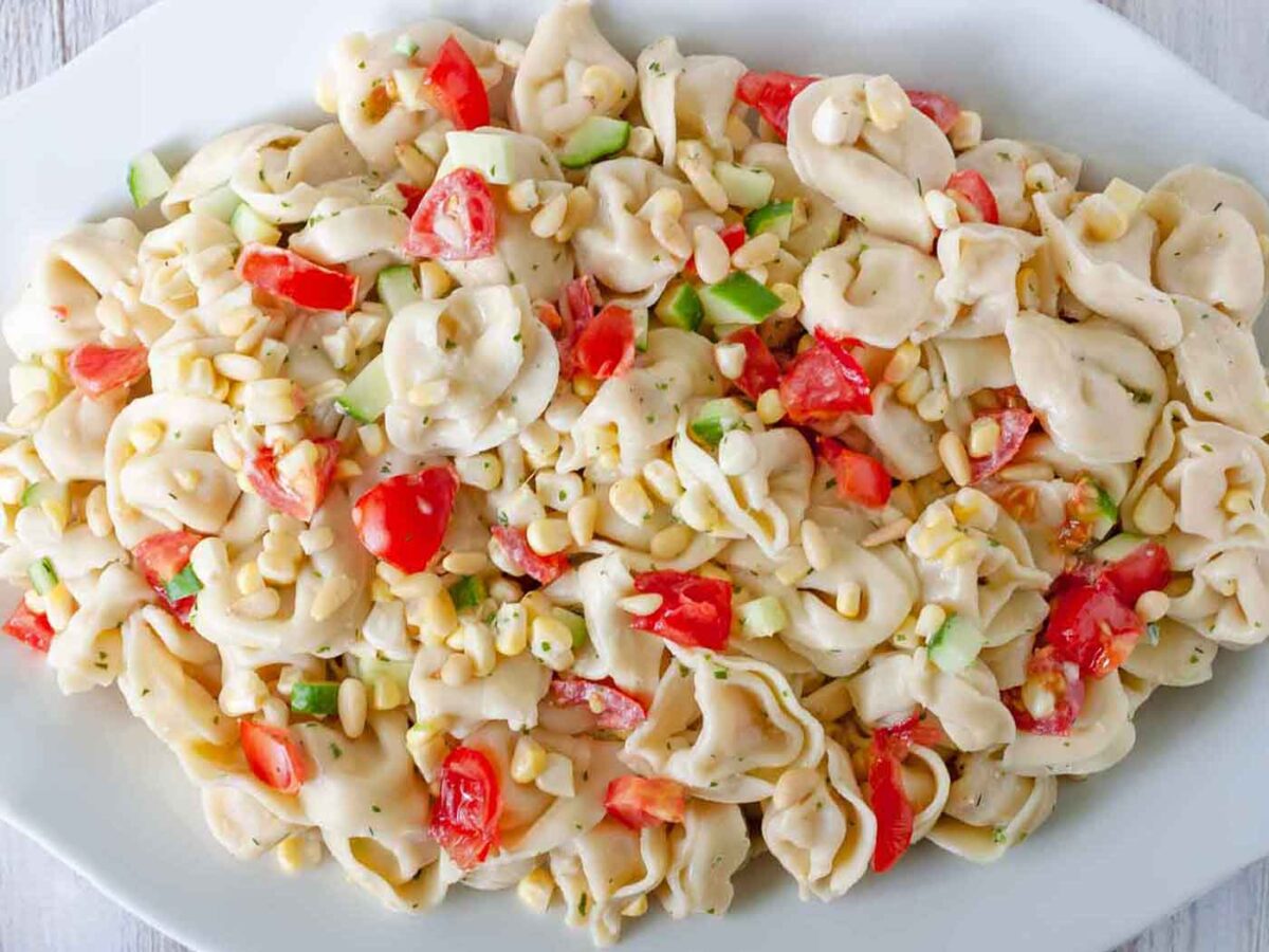 Overhead view of Summer Tortellini Salad on a white serving plate.