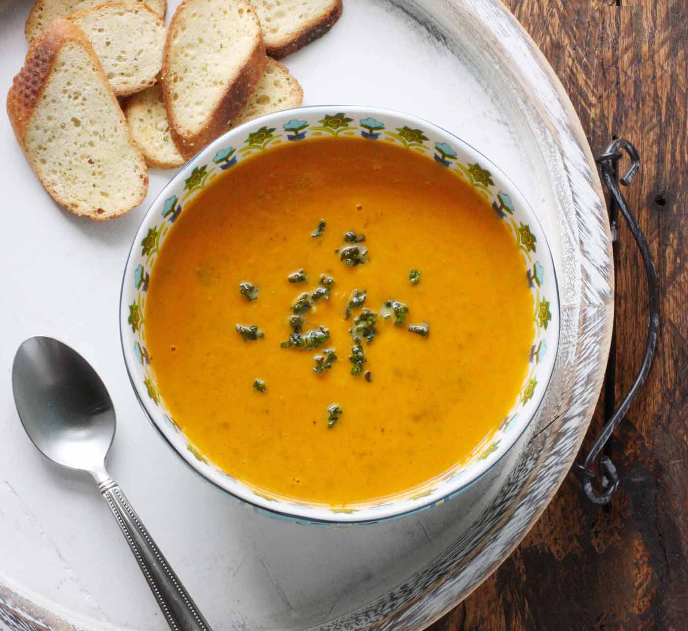 Sweet Potato Sausage Soup in a bowl on a white serving tray.