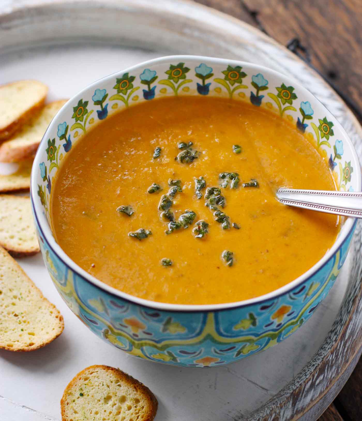Sweet Potato Sausage Soup on a serving tray with bread slices.