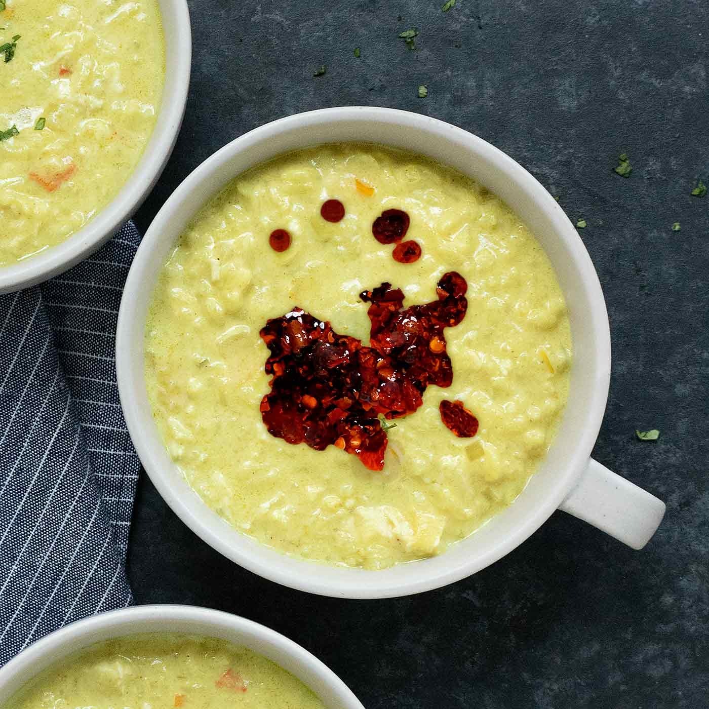 Tom Kha Gai in a gray bowl topped with chili crisp.
