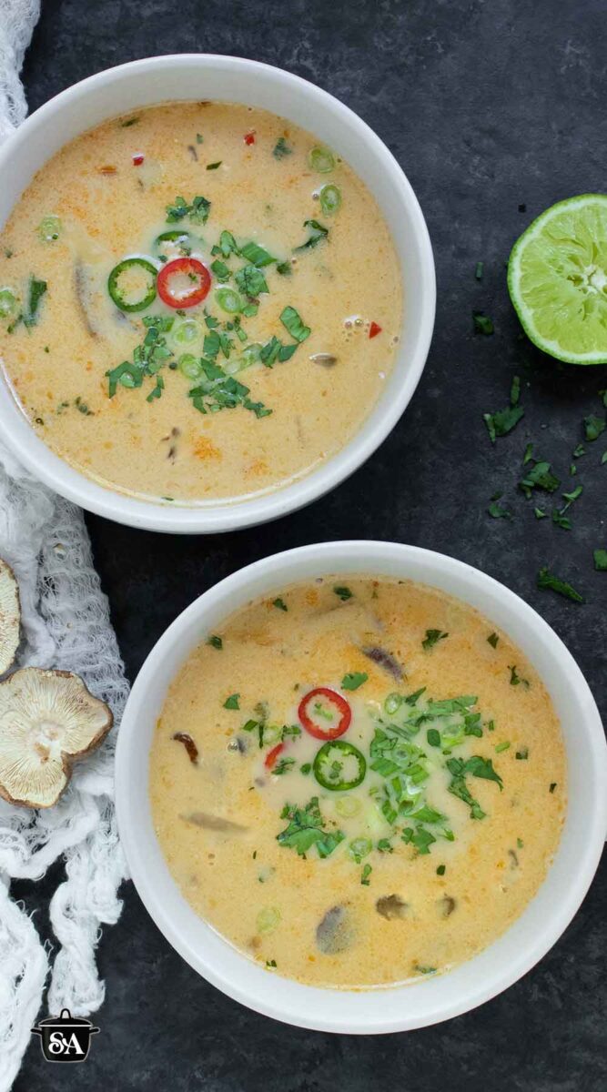 Pinterest pin image for Thai Coconut Mushroom Soup, with an overhead shot of two bowls of the soup.