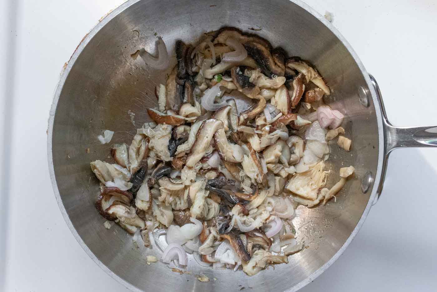 Sauteeing the mushrooms and shallots in the pot.