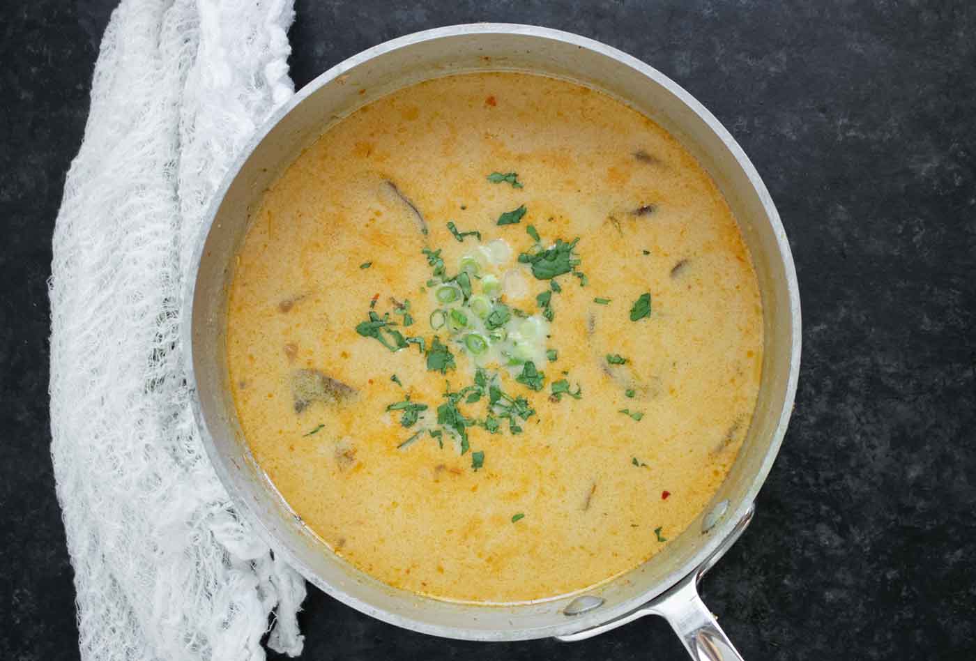The finished soup in the pot, with cilantro and green onions.