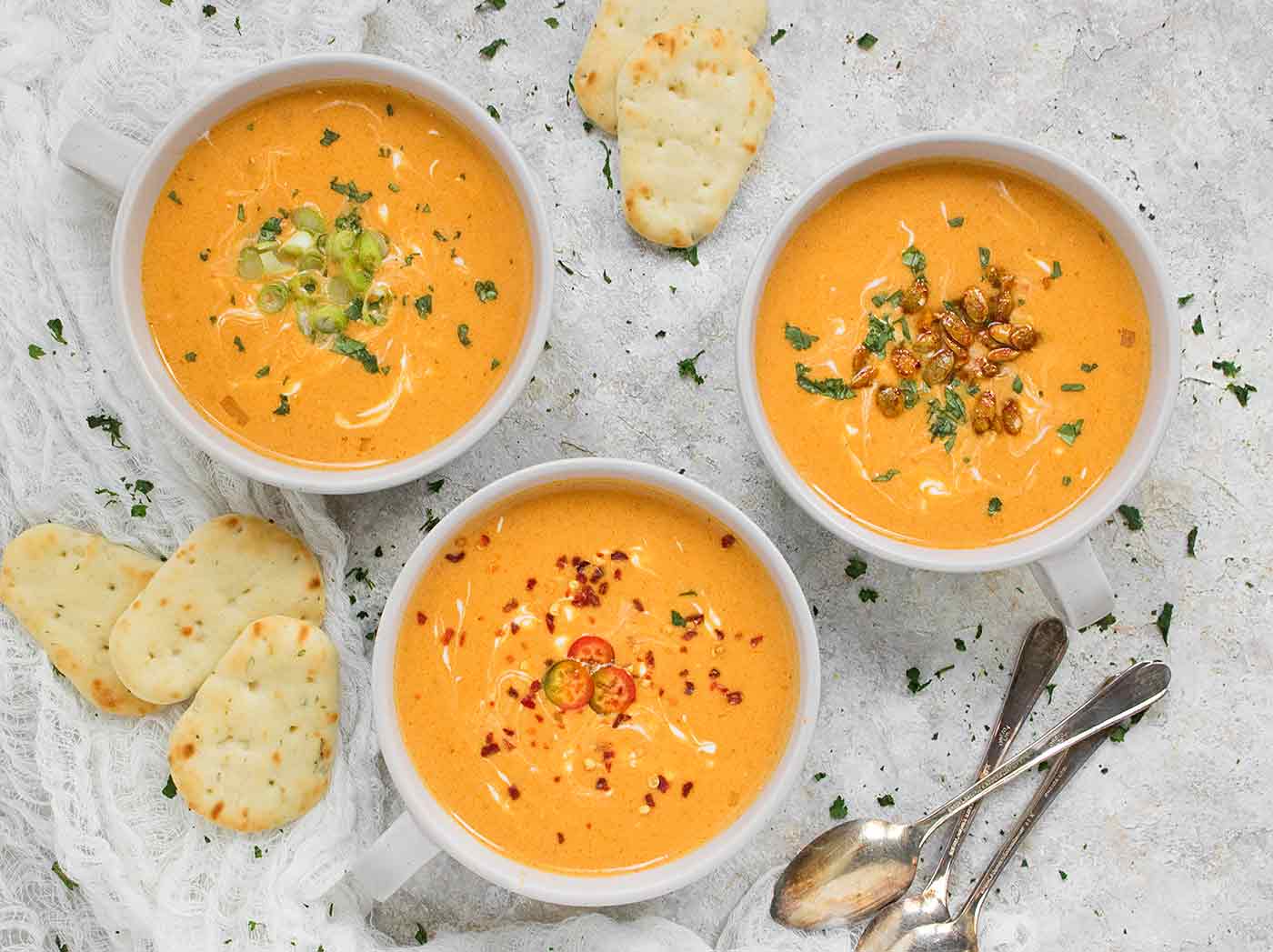 Three bowls of Thai Pumpkin Soup with toppings
